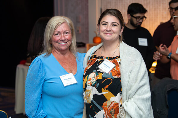 Three USALLIANCE Financial employees standing together and smiling at a company event.