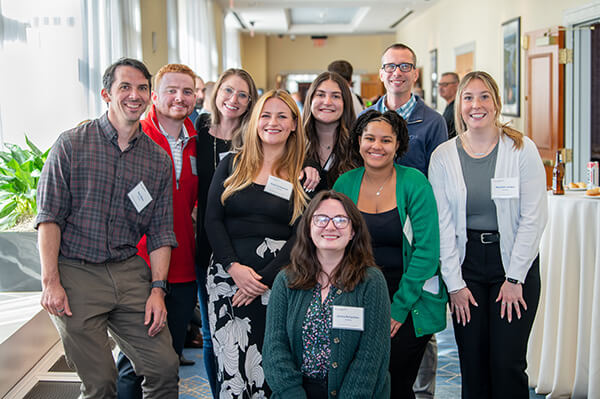 A group of USALLIANCE Financial employees standing together and smiling at a company event.