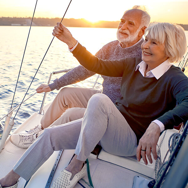A couple sit on a boat in the sunset